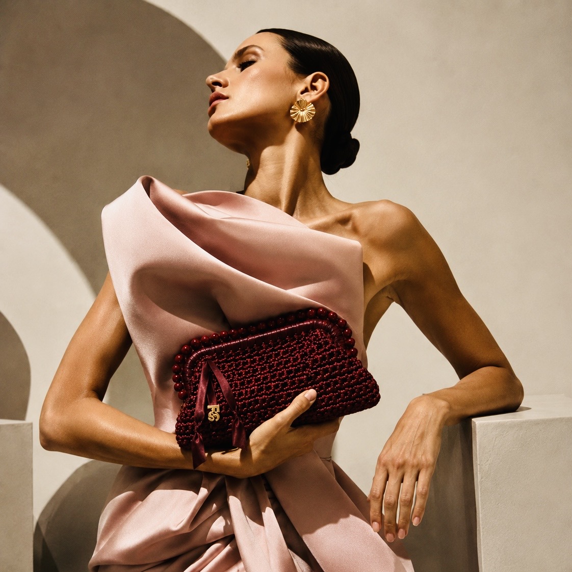 Model carrying a hand-crocheted burgundy satin cord handbag